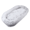 A human-specific dog bed featuring a washable faux fur design